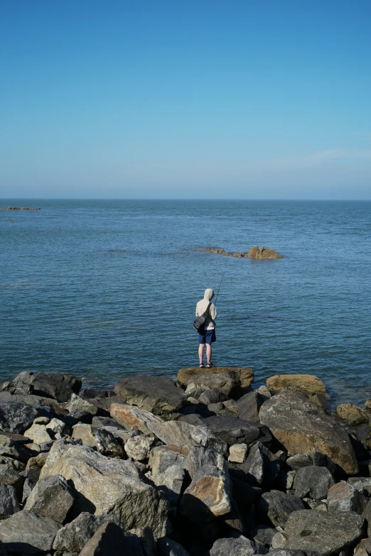 a person on rocks by the water