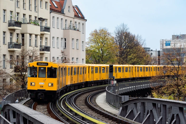 a yellow train is going down a track