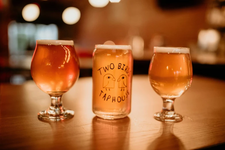 four different beers are sitting on the bar