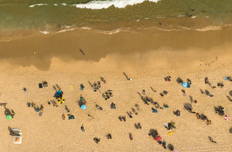 a beach with some sand and people walking around it