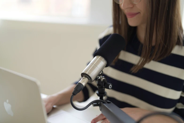 a woman holding a microphone over a laptop