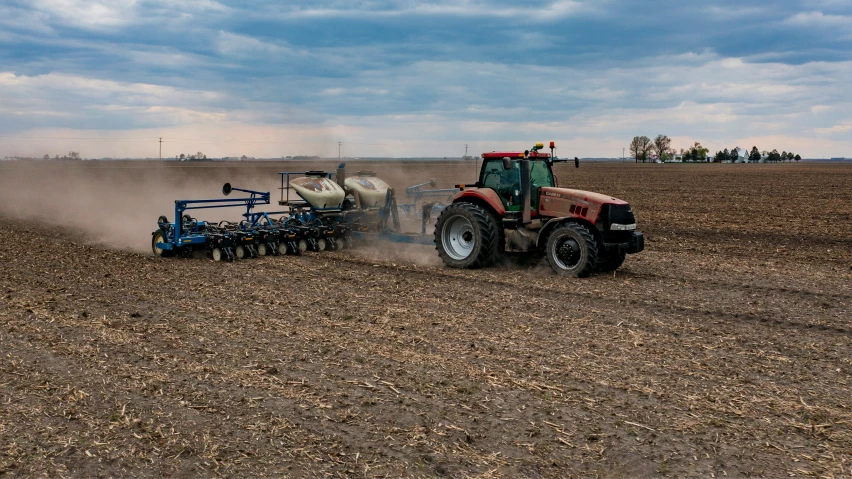 a tractor plowing fields with a sill to sow