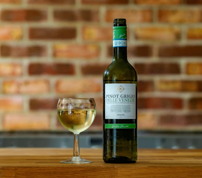 bottle of wine and glass of liquid on a wooden table