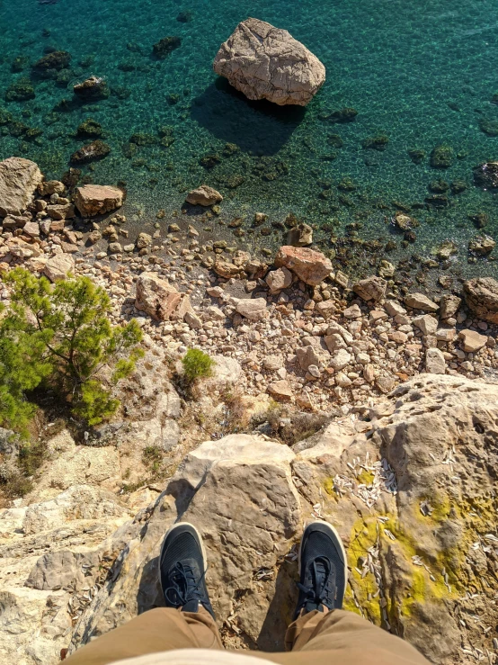 the view from the top of the person's shoes looking out over water