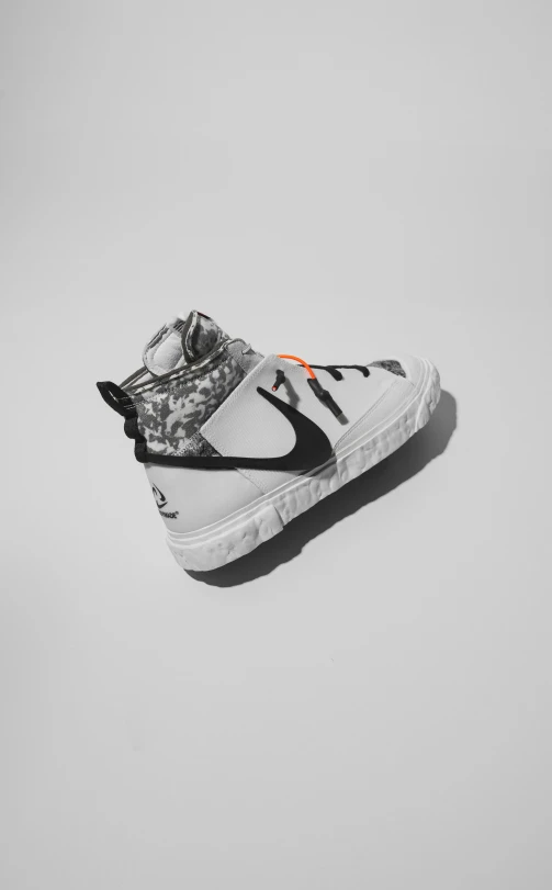 a white shoe with black and orange detailing