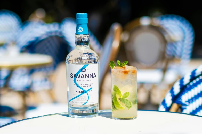 a bottle with a drink next to a glass filled with ice