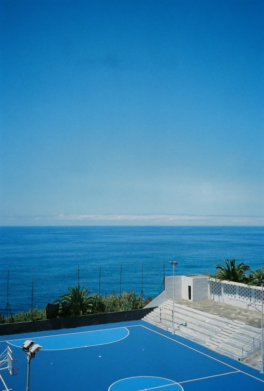 a tennis court on a nice day overlooking the ocean