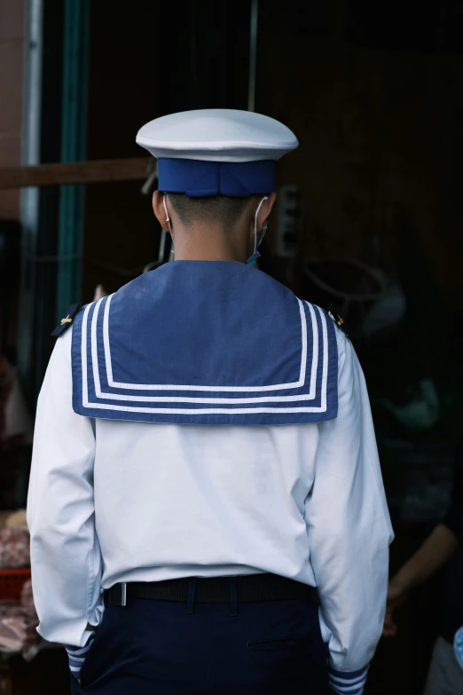 a sailor stands in front of another boat captain