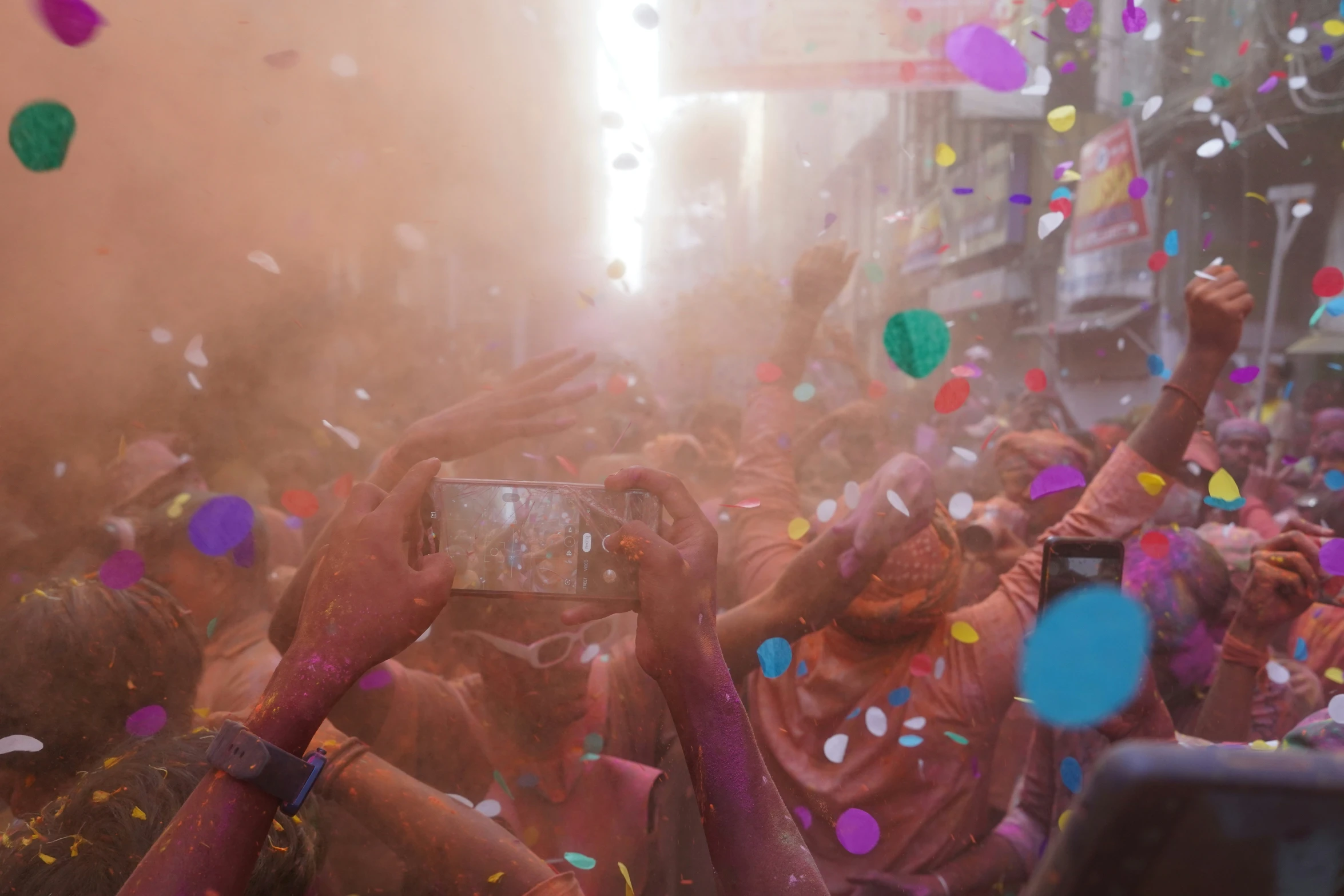 a crowd at a colorful festival takes pictures