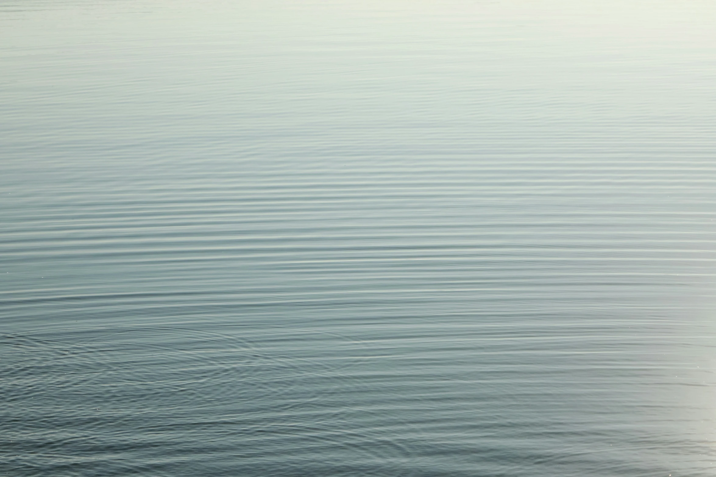 the man is rowing on a very calm body of water