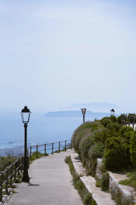 a walkway with a light post next to a beach