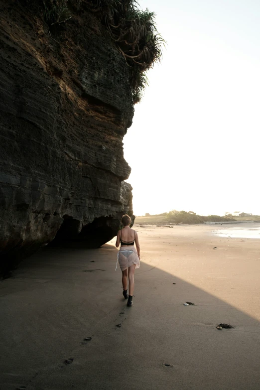 a woman walking on the beach in her underwear