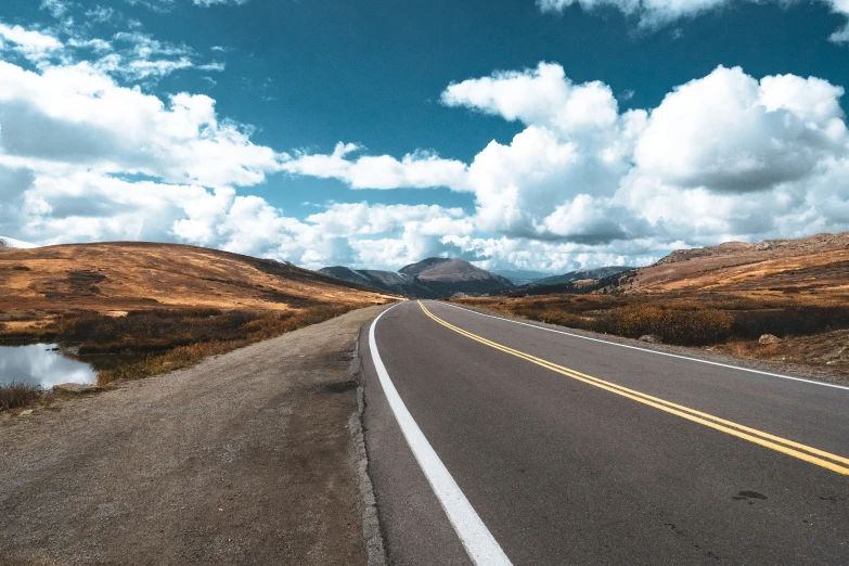 a road with grass and a body of water on both sides