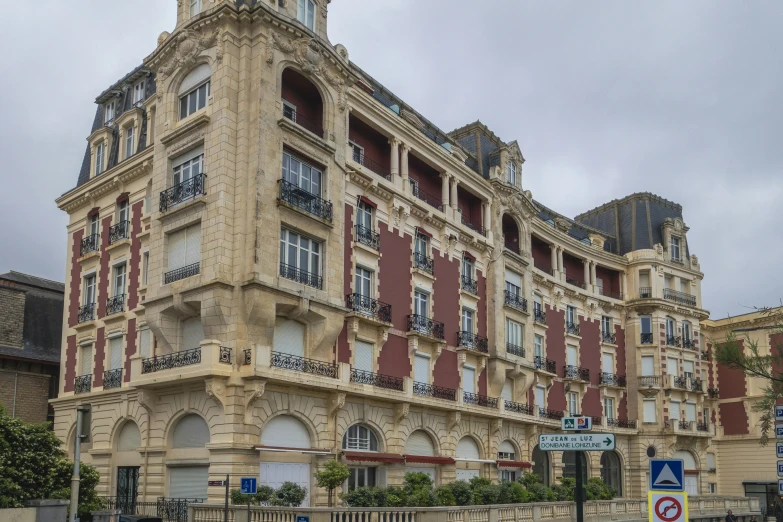 the tall building with red shutters has an ornate balcony