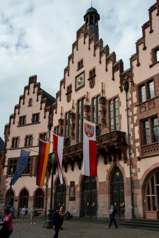 a building with flags, and two people standing by it