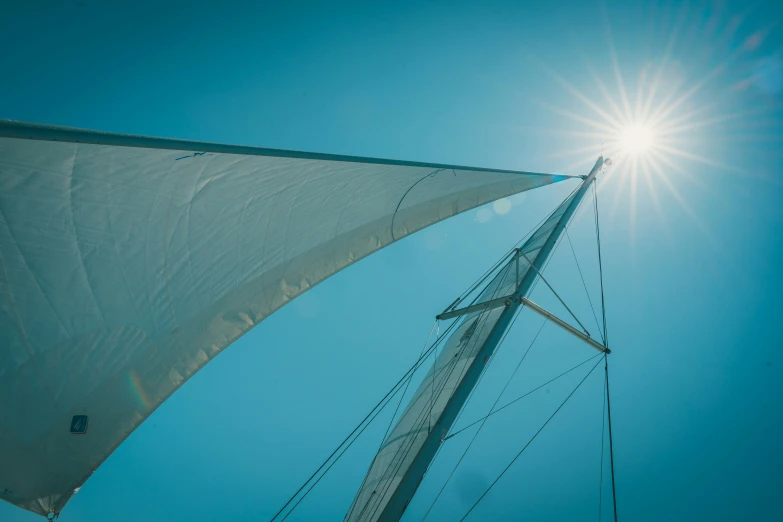 the top of a sail boat with sun shining in the sky