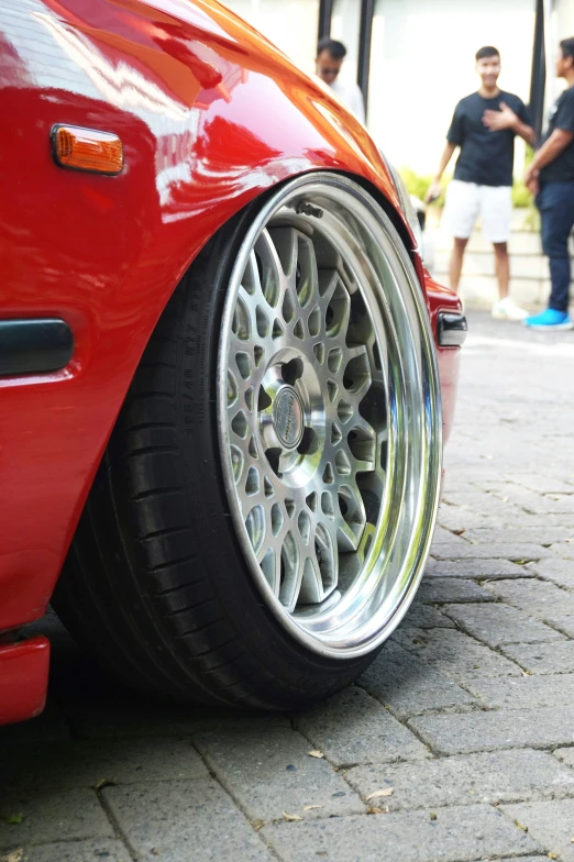 a close - up view of the wheels and rims of a red sports car