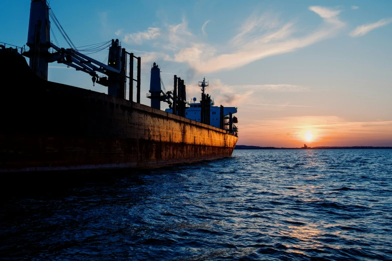 the sunset on a large ship is seen at sea