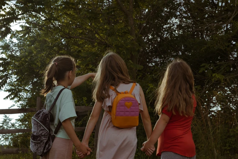 the three girls are walking hand in hand together