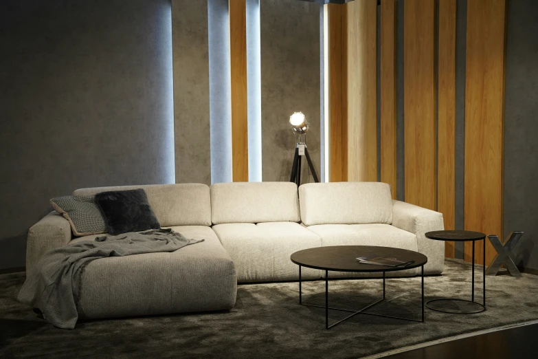 a white sectional couch sits on a gray carpet next to a lamp