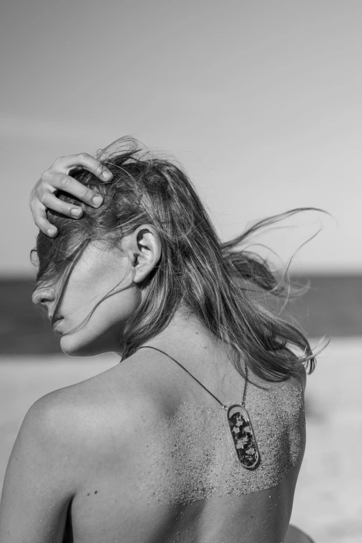 black and white pograph of woman back with hair blowing in the wind