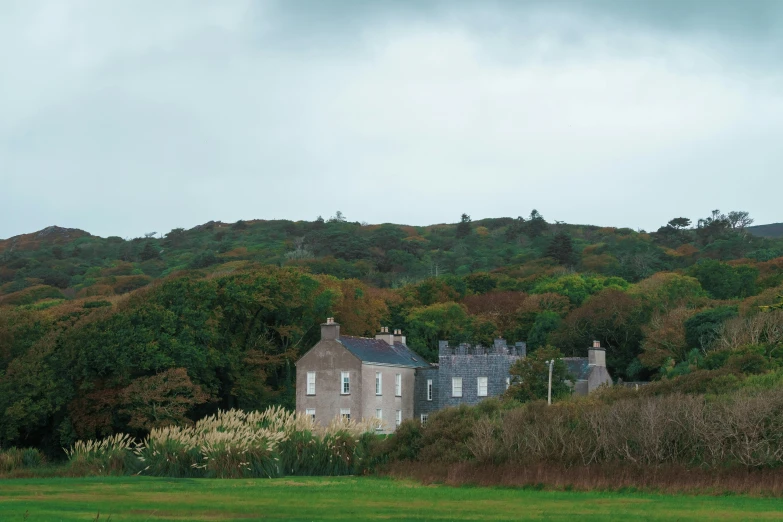 a stone house on a hill with green grass