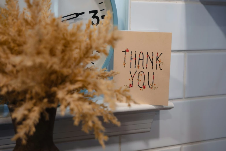 a small clock with a note stating thank you