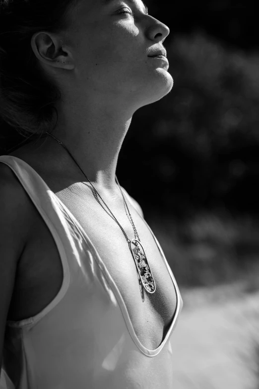 a young woman wearing necklace and tank top with neck tattoo