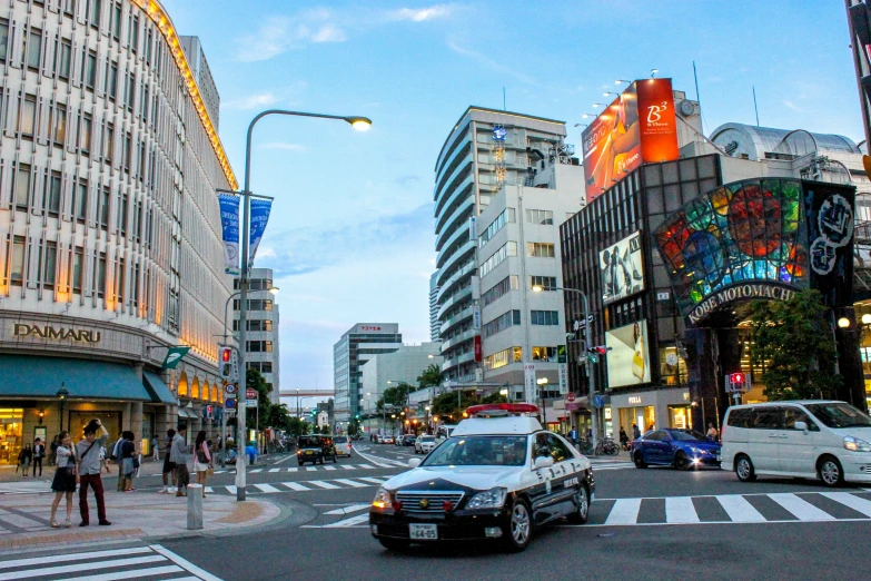 busy city street with cars, pedestrians, and advertits