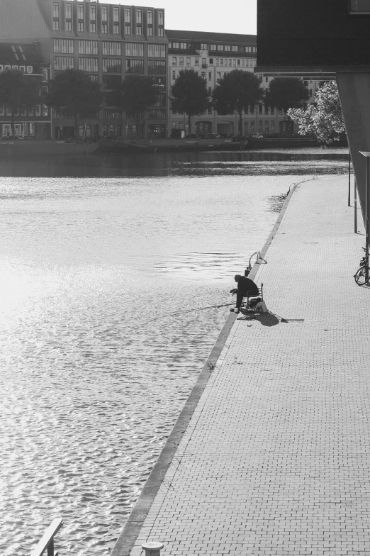 a person sitting on a bench next to a lake