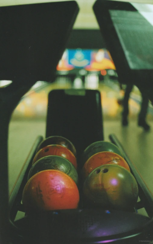 several balls sit on a skateboard in a bowling alley