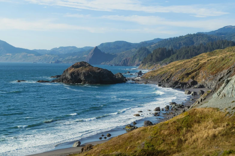 a beach is shown with a rocky coastline next to the ocean