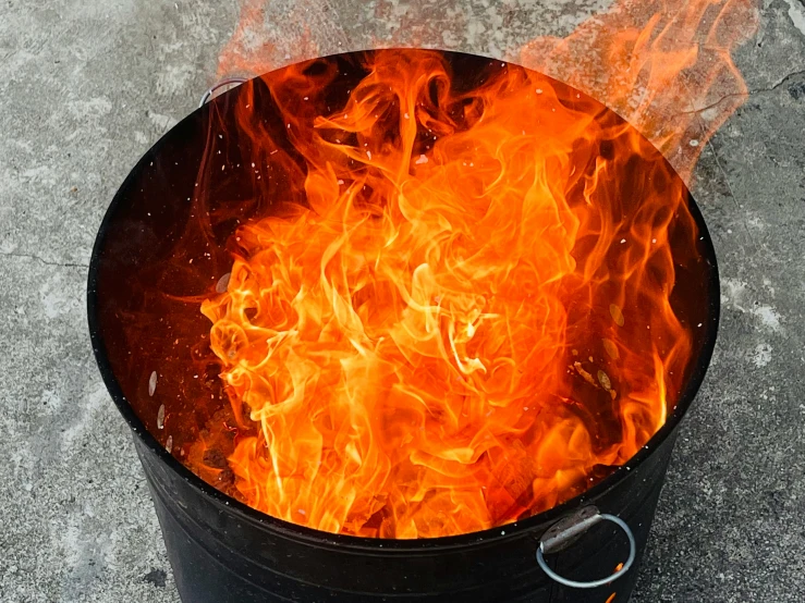 a metal barrel with fire in the middle