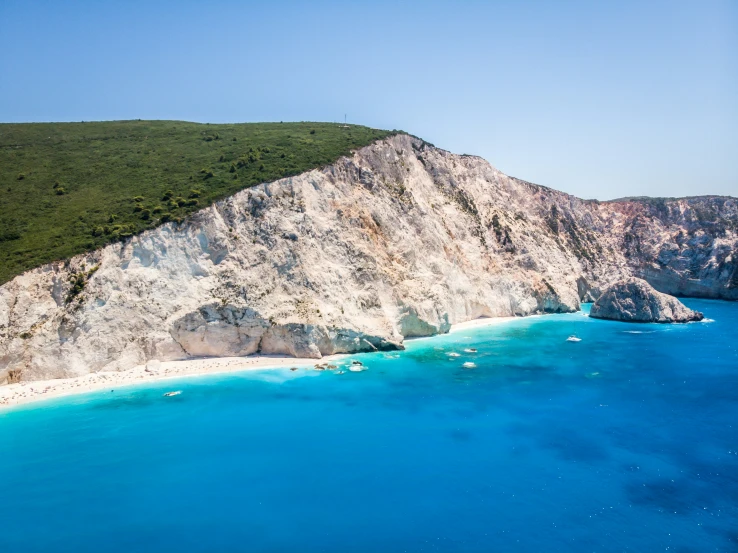 the clear blue water next to the cliff