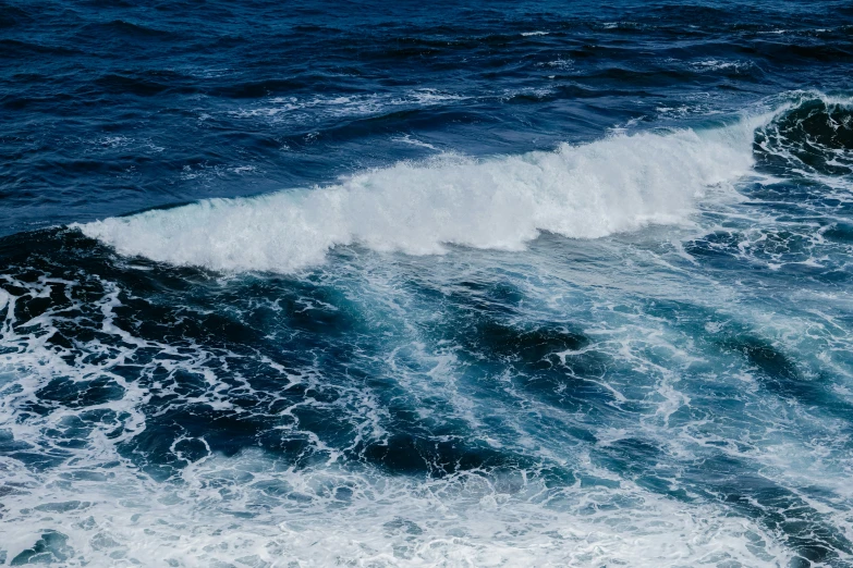 ocean wave with an overcast sky and light blue ocean