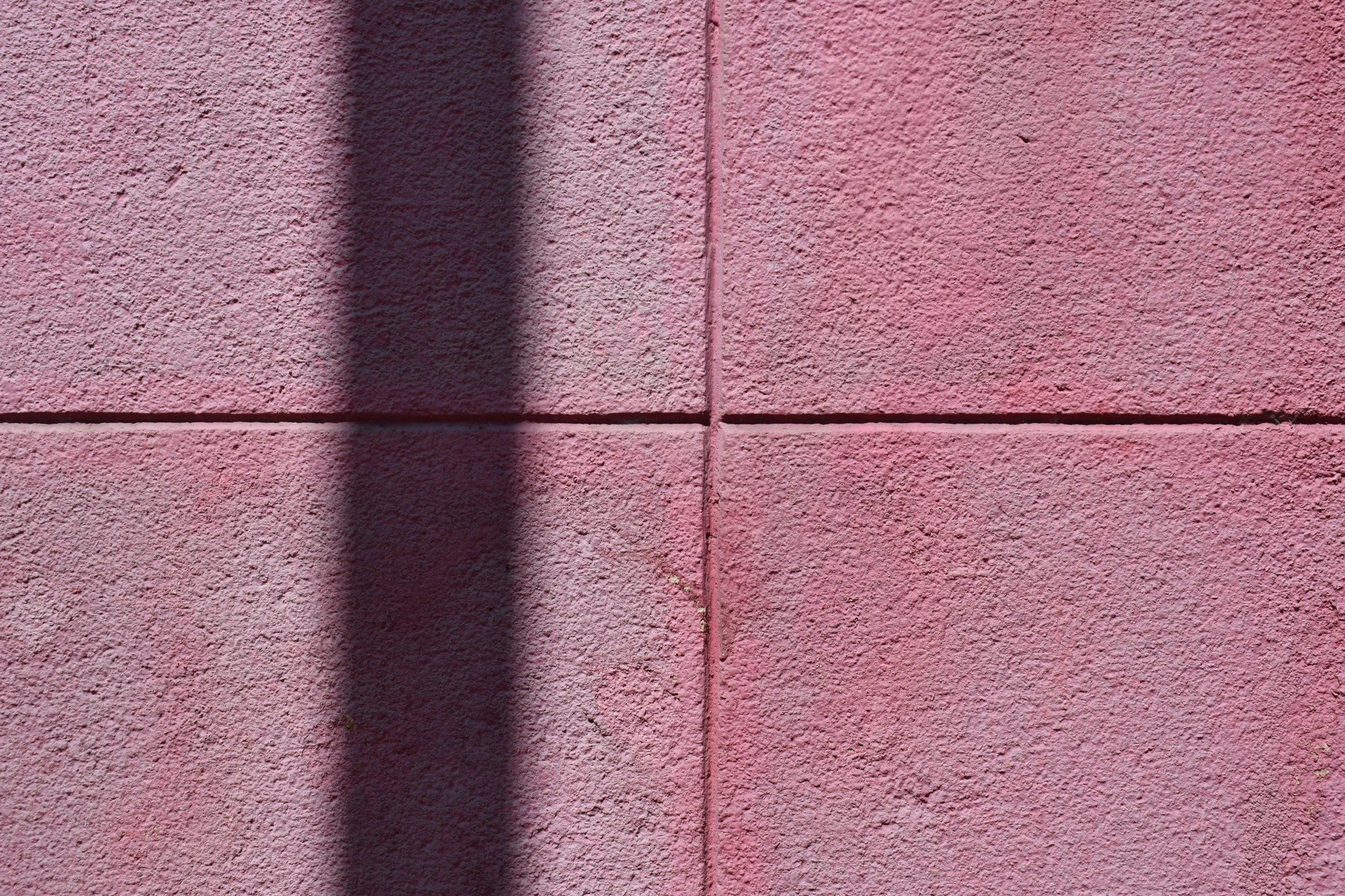 the shadow of a person walking on the side of a building