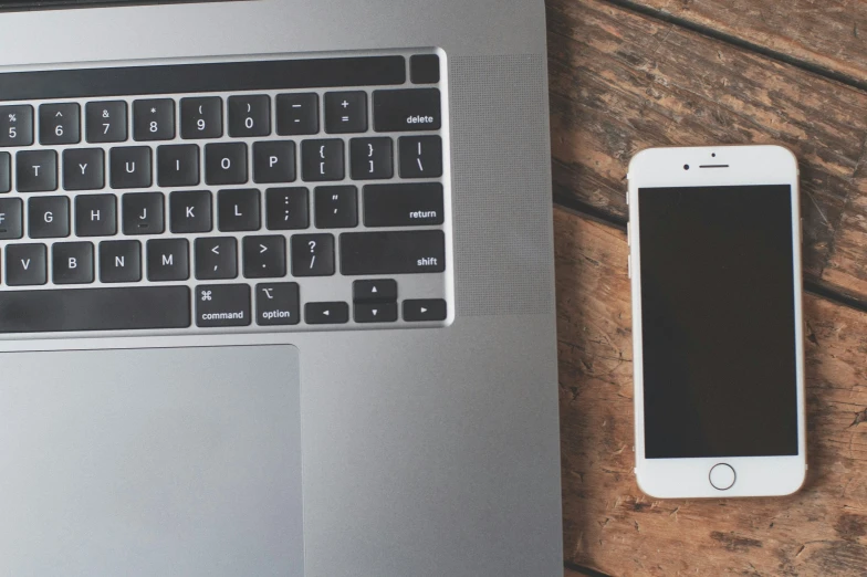 an iphone sitting on top of a laptop keyboard