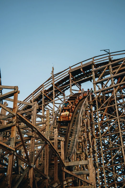 a roller coaster going around a wooden track