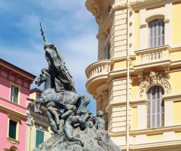 a statue stands outside a building with tall windows