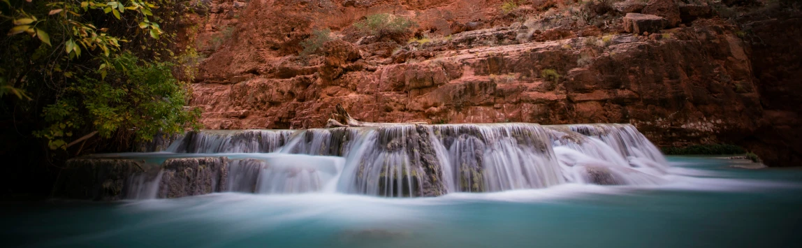 there is a waterfall with a man on top of it