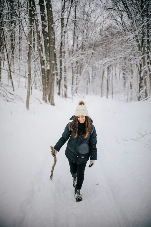 a woman cross country skiing through a forest