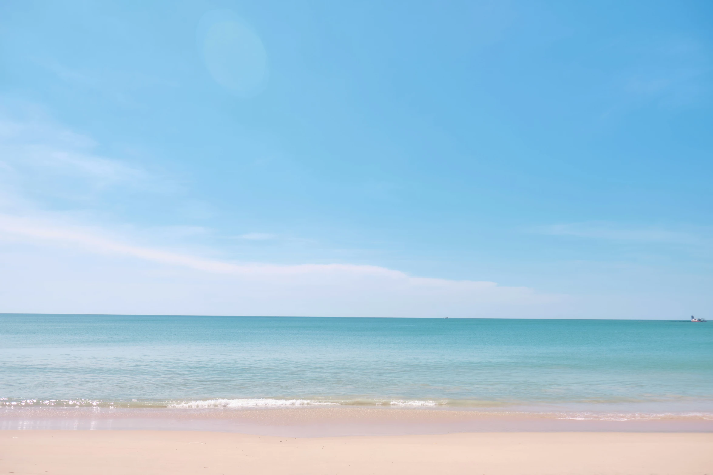an empty beach with blue sky and clear water
