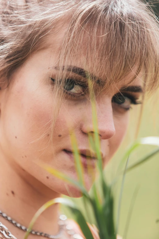 the woman is holding onto a plant outside