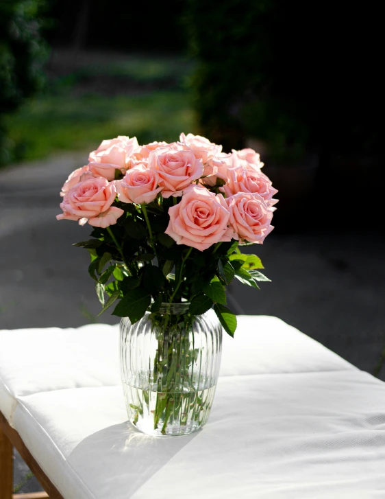 pink flowers on a glass vase on a white table