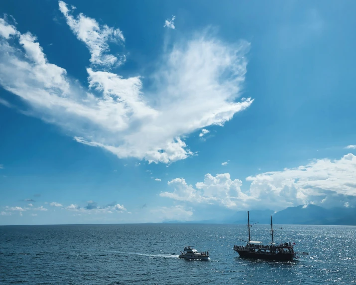 some boats that are in the water under some clouds