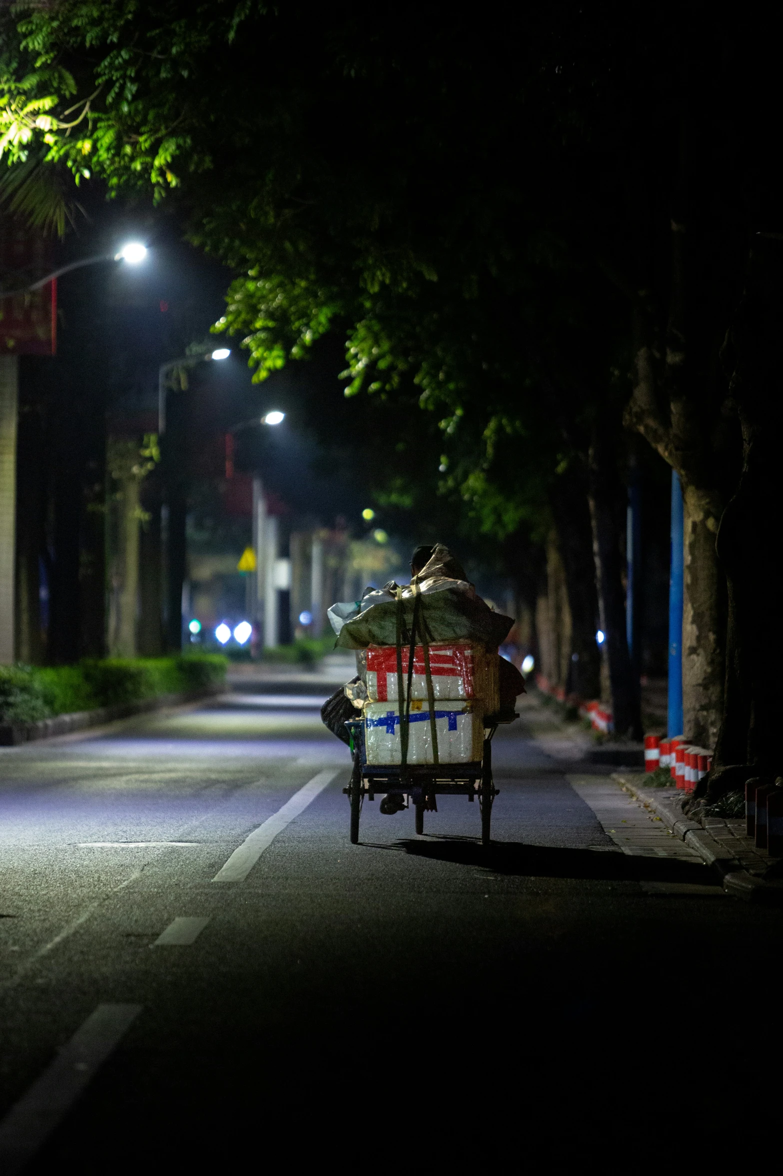 a man riding a cart down a street at night