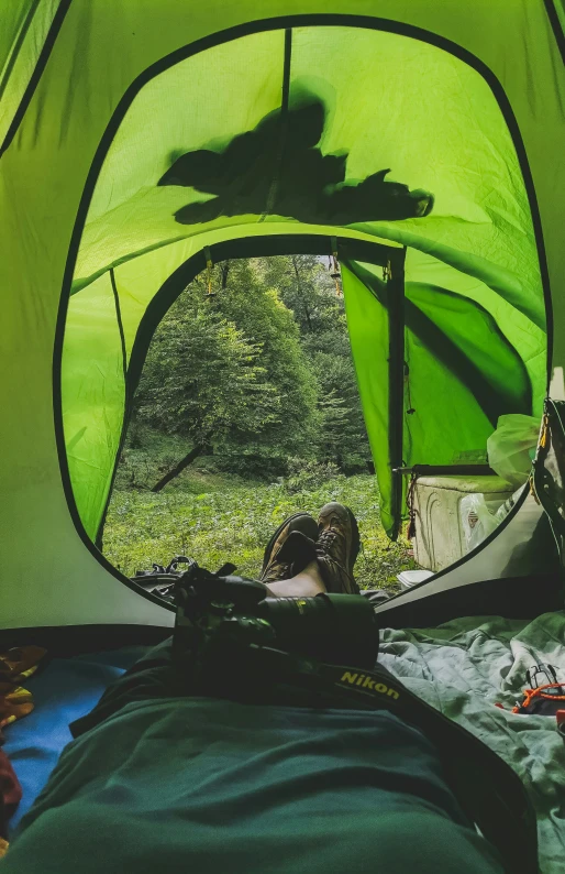 the inside of a green tent with a man sitting at the front