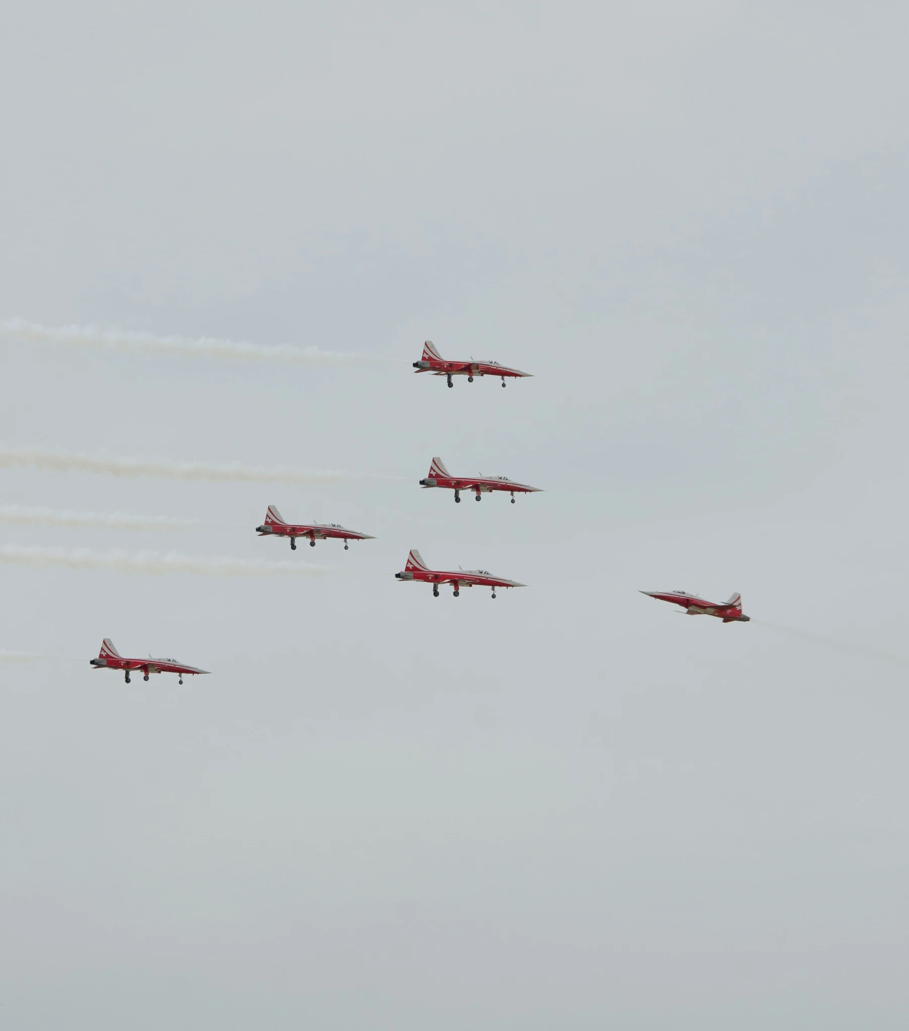 five jets flying thru the air while leaving smoke trails