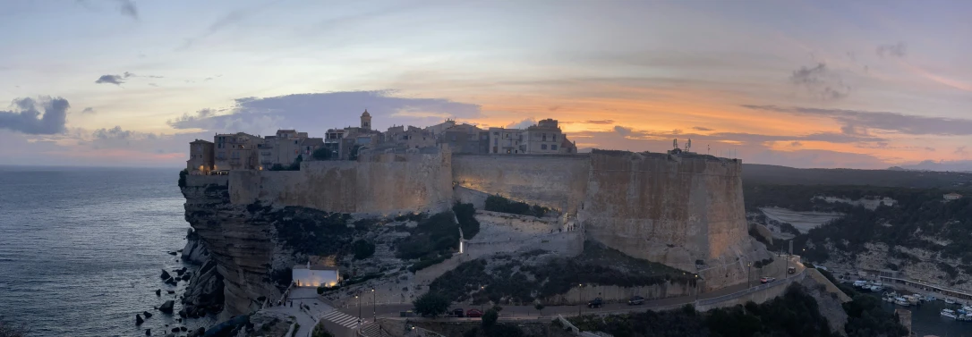 the view of an old castle on the side of the cliff