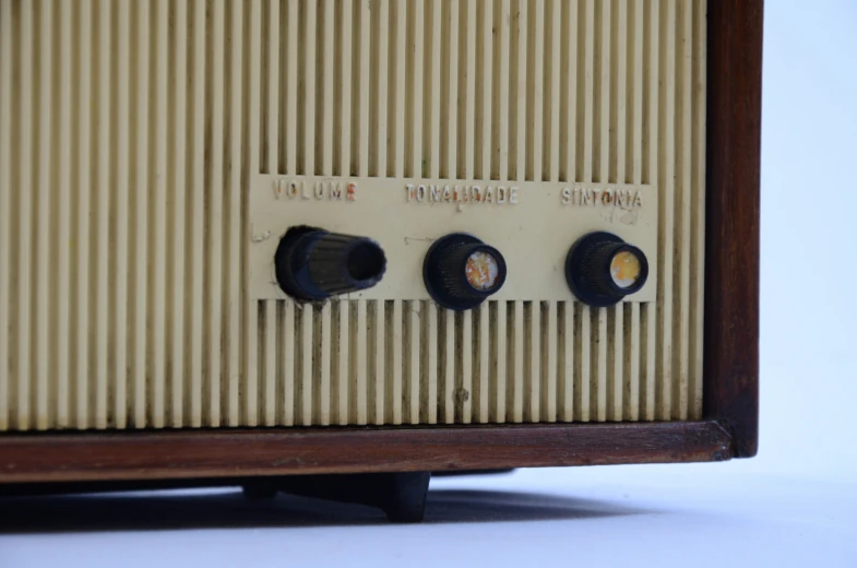 two old style radio controls are hanging from the side